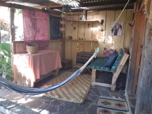 a hammock in a room with a table and a table at Earthship amazing Cabins with lake view in San Marcos La Laguna