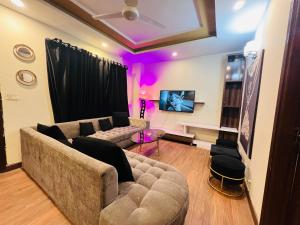 a living room with a couch and pink lighting at Stylish & Serene 2BHK Apt in Islamabad
