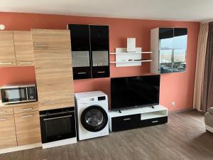ein Wohnzimmer mit einer Waschmaschine und einem TV in der Unterkunft schönes Apartment mit Festungsblick - FREE Parking - in Würzburg