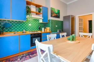 a kitchen with blue cabinets and a wooden table at [The Garden] Centro Storico + Free Parking + Wi-Fi in Reggio Emilia