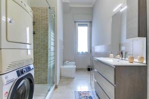 uma casa de banho com um lavatório e uma máquina de lavar roupa em [The Garden] Centro Storico + Free Parking + Wi-Fi em Reggio Emilia