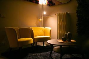 uma sala de estar com uma cadeira amarela e uma mesa em [The Garden] Centro Storico + Free Parking + Wi-Fi em Reggio Emilia