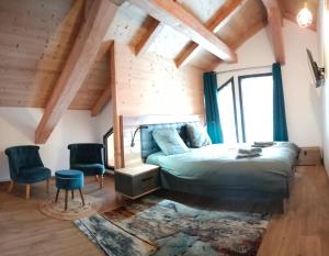 een slaapkamer met een bed in een kamer met houten plafonds bij Chalet Kelly in Les Orres