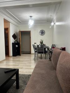 a living room with a couch and a table and a clock at Joli appartement centre Casablanca in Casablanca