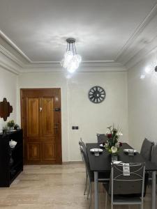 a dining room with a table and a clock on the wall at Joli appartement centre Casablanca in Casablanca
