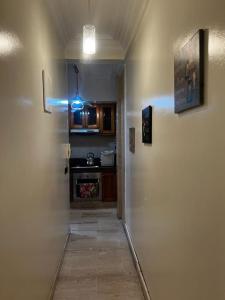 a hallway leading to a kitchen with a door to a room at Joli appartement centre Casablanca in Casablanca