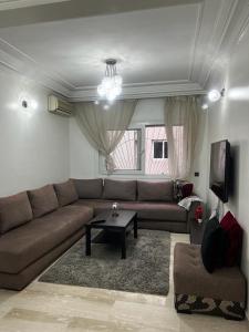 - un salon avec un canapé et une table dans l'établissement Joli appartement centre Casablanca, à Casablanca