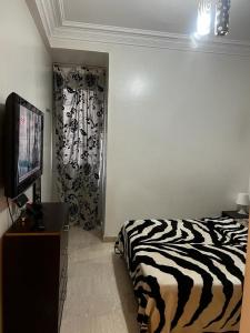 a bedroom with a zebra print bed and a television at Joli appartement centre Casablanca in Casablanca