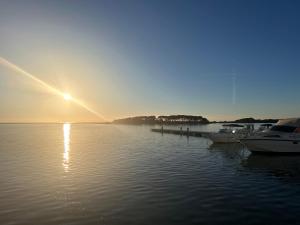 a sun setting over a body of water with boats at Casa Elisa in Porto Cesareo