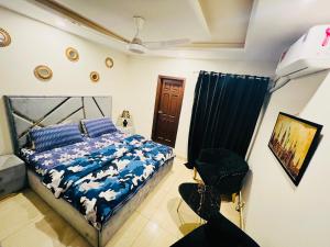 a bedroom with a bed and a chair at Stylish & Serene 2BHK Apt in Islamabad