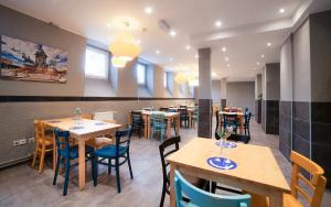 a restaurant with wooden tables and blue chairs at a&o Wien Stadthalle in Vienna