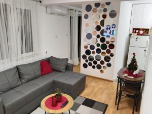 a living room with a gray couch and a table at Apartman VUK in Pirot