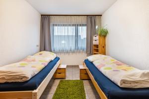 2 łóżka w małym pokoju z oknem w obiekcie Ferienwohnung Frische Brise w mieście Grafenhausen