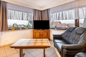 a living room with a couch and a flat screen tv at Ferienwohnung Frische Brise in Grafenhausen