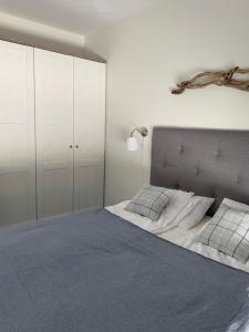Un dormitorio con una cama grande con sábanas y almohadas azules. en Apartament Hamptons Perłowa Przystań, en Sianożęty