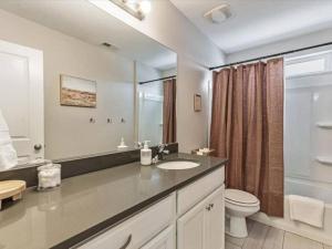 La salle de bains est pourvue d'un lavabo, de toilettes et d'un miroir. dans l'établissement Pet Friendly, Fully Fenced & Grass Backyard, à American Fork