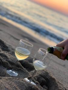 dos copas de vino en la arena en la playa en Apartament Hamptons Perłowa Przystań, en Sianożęty 18 fotos más