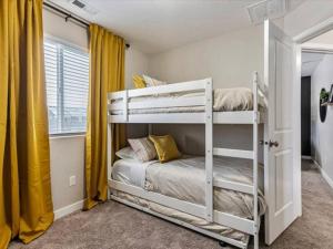 - une chambre avec 2 lits superposés et des rideaux jaunes dans l'établissement Pet Friendly, Fully Fenced & Grass Backyard, à American Fork