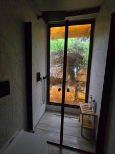 La salle de bains est pourvue d'une porte s'ouvrant sur une grande fenêtre. dans l'établissement מעיין הגלבוע, à Gid‘ona