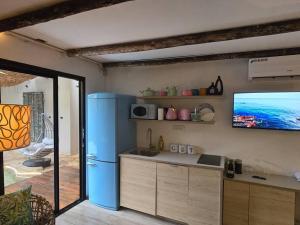 a kitchen with a blue refrigerator and a flat screen tv at מעיין הגלבוע in Gid‘ona