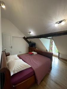 um quarto com uma cama grande num sótão em Appartement 1 chambre et Mezzanine em Hargeville