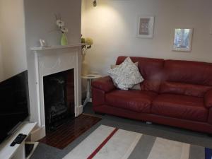 a red leather couch in a living room with a fireplace at Pebble Reef in Portland