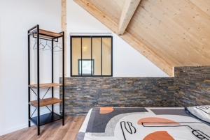 ein Schlafzimmer mit einem Bett und einer Ziegelwand in der Unterkunft La Cabane du Huga N°2 in Lacanau