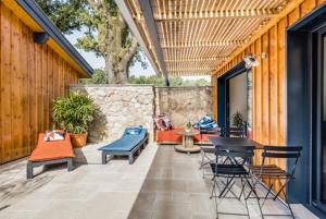 eine Terrasse mit Stühlen, einem Tisch und Stühlen in der Unterkunft La Cabane du Huga N°2 in Lacanau