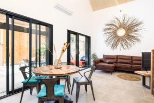 ein Wohnzimmer mit Tisch und Stühlen und einer Couch in der Unterkunft La Cabane du Huga N°2 in Lacanau