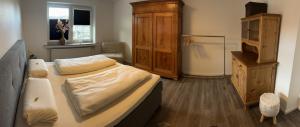 Schlafzimmer mit einem Bett und einem Holzschrank in der Unterkunft Kragemann Hotel & Vinothek in Simmerath