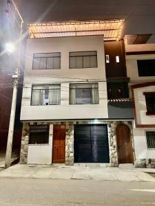 a white building with two doors and a garage at Morada Apart in Tacna