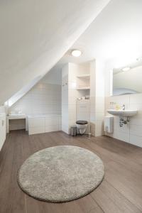 łazienka z dywanem, umywalką i toaletą w obiekcie Kavaliershaus Krumke - Gästehaus im Schlosspark w mieście Krumke