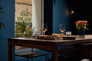 a table with two glasses of wine and food on it at Sant Jaume Design Hotel in Palma de Mallorca