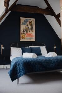 a bed with a blue comforter in a room at Grade II Listed Flint Cottage Sleeps 4 in Norwich