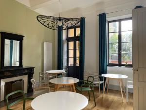 une chambre avec des tables, des chaises et une cheminée dans l'établissement B&B Les chambres d'Aimé, à Carcassonne