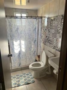 La salle de bains est pourvue de toilettes et d'un rideau de douche. dans l'établissement Apartment near Airport & beach security 24/7, à La Cana