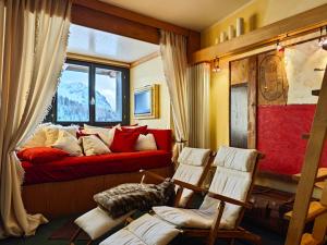 a living room with a red couch and a window at Hostdomus - 007 Luxury Suites in Sestriere