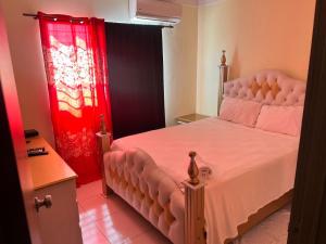 - une chambre avec un lit et un rideau rouge dans l'établissement Apartment near Airport & beach security 24/7, à La Cana