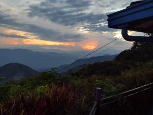 um pôr-do-sol numa montanha com vista para as montanhas em Finca Emilio em Fredonia