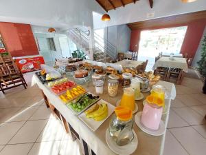 um buffet de pequeno-almoço com frutas e sumos numa mesa em Pousada Pompeia em Socorro