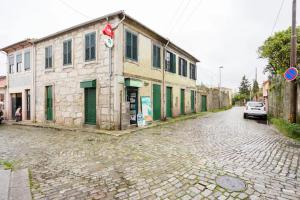 une rue en briques avec un bâtiment sur son côté dans l'établissement House CONTU1000, à Porto