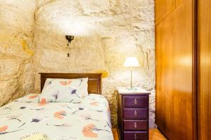 a bedroom with a bed in a stone wall at House CONTU1000 in Porto