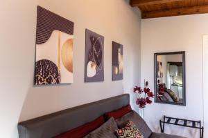 un soggiorno con divano e alcune immagini sul muro di Villa Lory a Agrigento