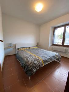 ein Schlafzimmer mit einem Bett in einem Zimmer mit einem Fenster in der Unterkunft Perla alpina in Abetone