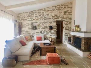 - un salon avec un canapé blanc et une cheminée en pierre dans l'établissement Bergerie du Cap Corse, à Macinaggio