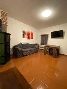 ein Wohnzimmer mit einem Sofa und einem Tisch in der Unterkunft Perla alpina in Abetone
