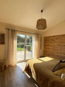 - une chambre avec un lit et une grande fenêtre dans l'établissement Bergerie du Cap Corse, à Macinaggio