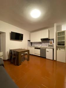 a kitchen with a table and a dining room at Perla alpina in Abetone
