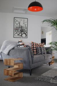 a living room with a gray couch with pillows at No. 82 Grade II Listed Norwich City Centre Flat in Norwich