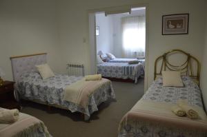 a room with three beds and a mirror at Espacio de la Patagonia in Comodoro Rivadavia